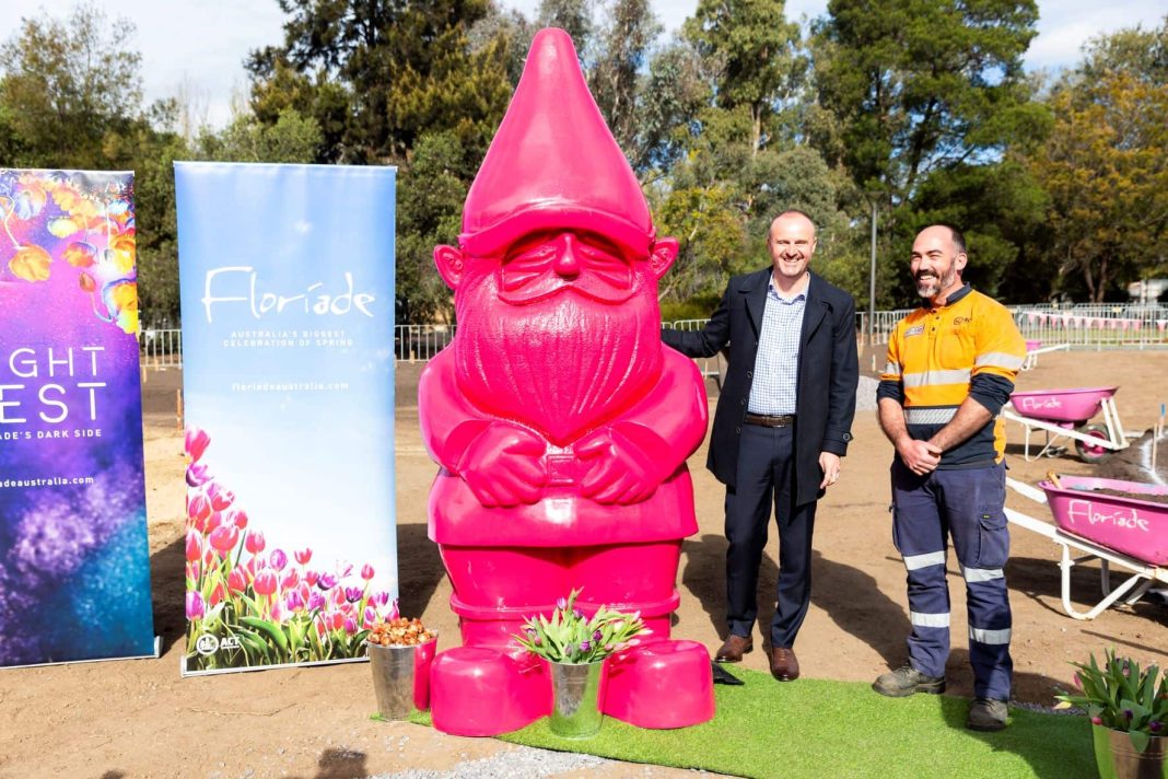 Two men with giant pink garden gnome at Floriade 2022 bulb planting photo opportunity in Commonwealth Park in Canberra