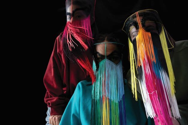 3 female musicians in colourful veiled costumes with fringing