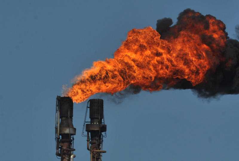 Smoke and flames spew from an industrial chimney at the Shell Refinery in Geelong