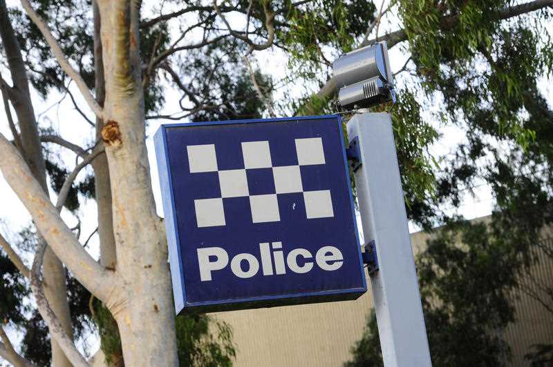 A blue and white check police station sign in Australia