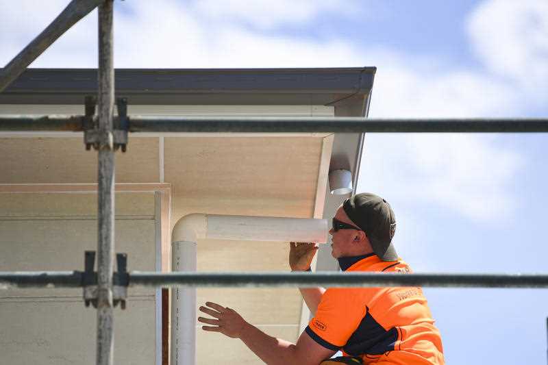 A plumber is seen working on a building site in Canberra
