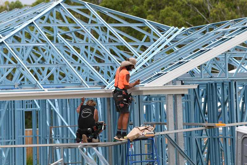 Workers are seen constructing a new home in a housing estate at Coomera, on the Gold Coast