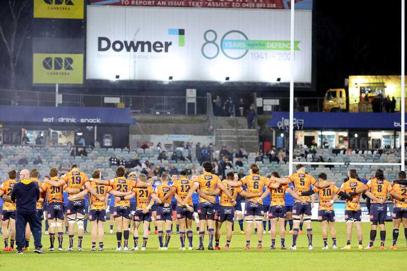 Players from the ACT Brumbies stand together before the start of a Super Rugby Pacific match at GIO Stadium Canberra
