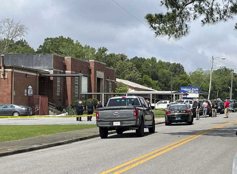 Officials gather outside Walnut Park Elementary School where a man was shot to death by police, Thursday, June 9, 2022, in Gadsden, Alabama