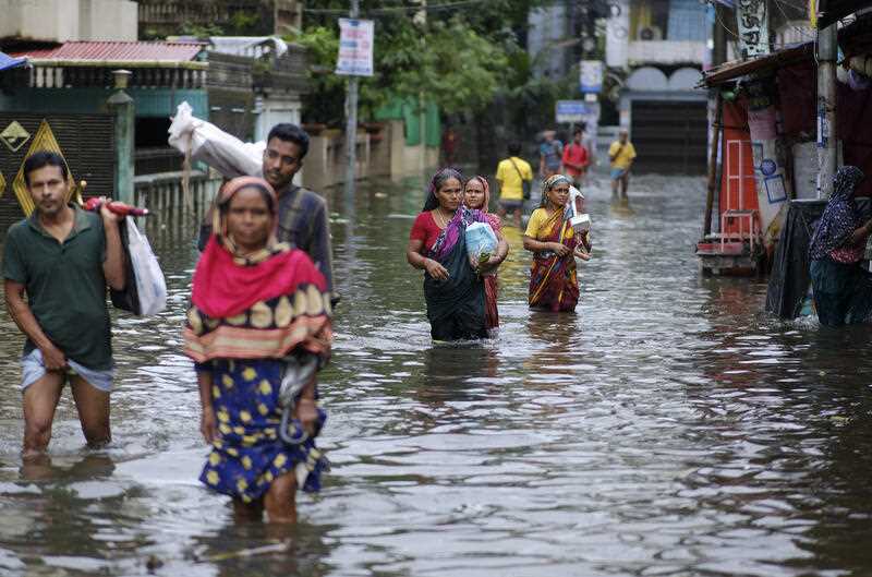 People wade through flood waters in Sylhet, Bangladesh, Monday, June 20, 2022