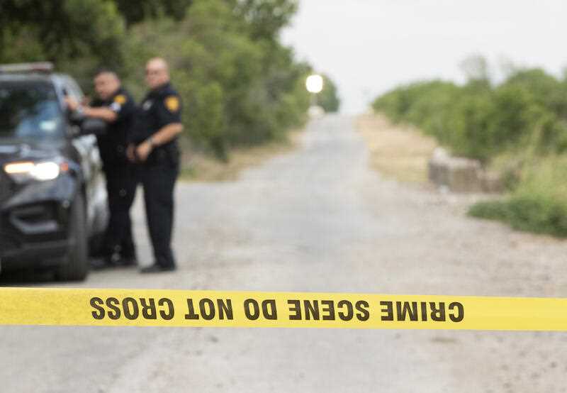 San Antonio police officers guard the scene Tuesday, June 28, 2022, in San Antonio where dozens of migrants were found dead in a tractor-trailer on Monday after being abandoned in the sweltering heat.