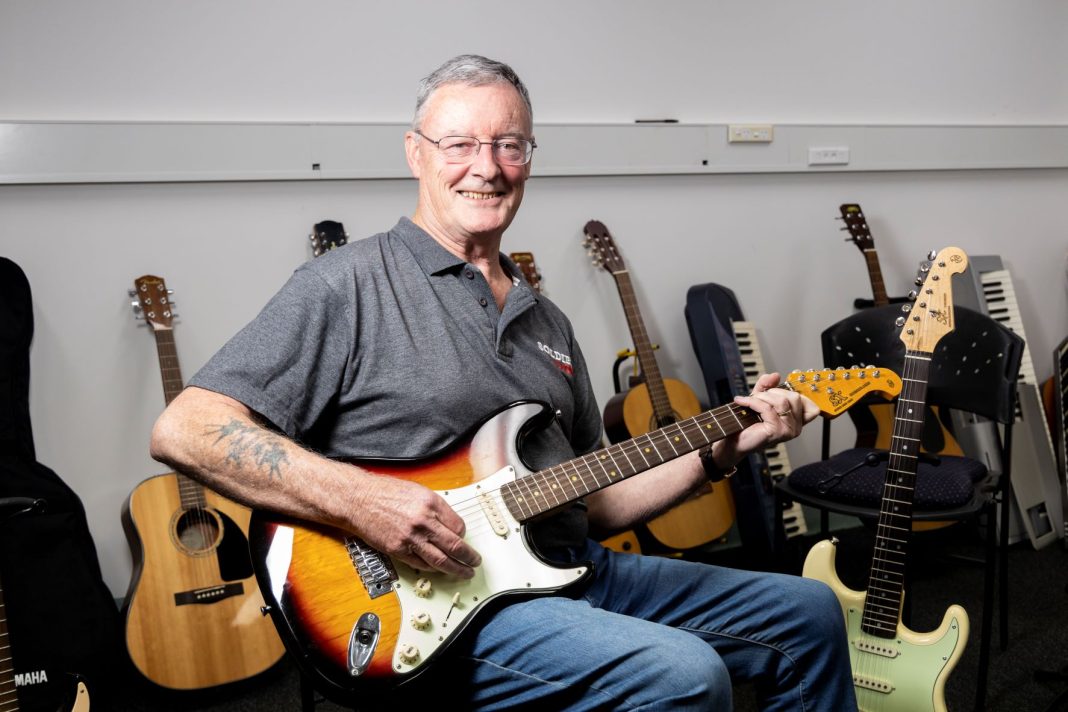 a 72 year old Navy veteran playing a guitar