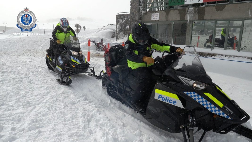 2 NSW police officers on snowmobiles in the snow
