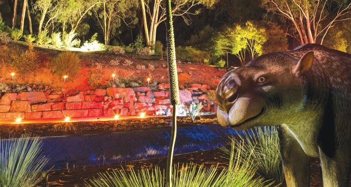 megafauna sculpture in gardens illuminated at night