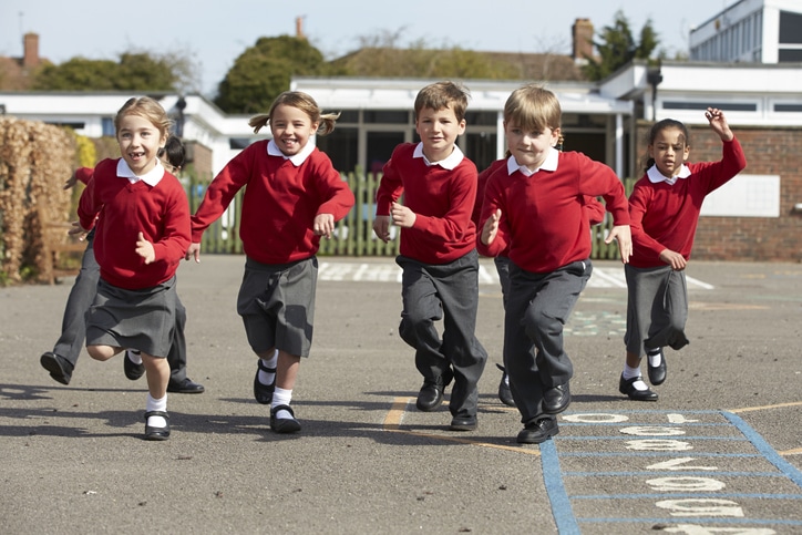 Elementary School Pupils Running In Playground Towards Camera