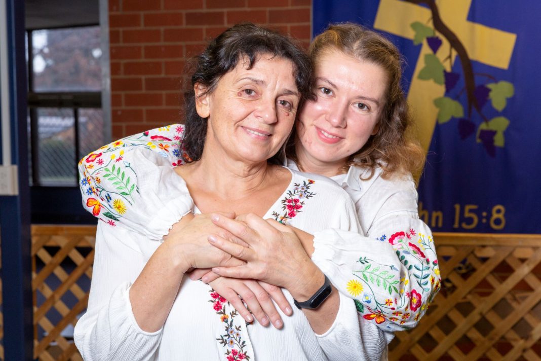 Ukrainian refugee mother and adult daughter hugging