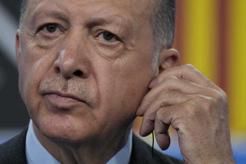 Turkish President Recep Tayyip Erdogan adjusts his earpiece as he listens to a question from a journalist during a media conference at a NATO summit in Madrid, Spain on Thursday, June 30, 2022