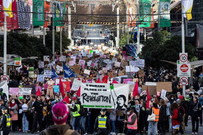 Demonstrators hold placards and signs as they march on Bourke Street Mall during a rally in support of abortion rights in Melbourne, Saturday, July 2, 2022