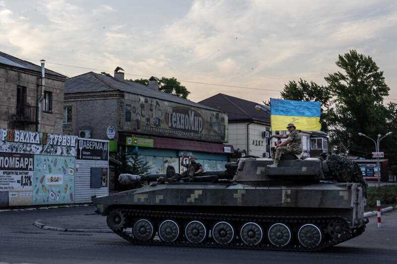 Ukrainian soldiers ride atop a tank through a street in Pokrovsk, Donetsk region, eastern Ukraine, Friday, July 8, 2022