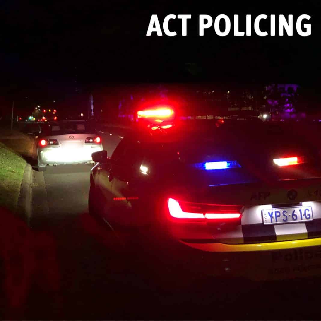 AFP police car at night in Canberra pulling over a white Mazda sedan