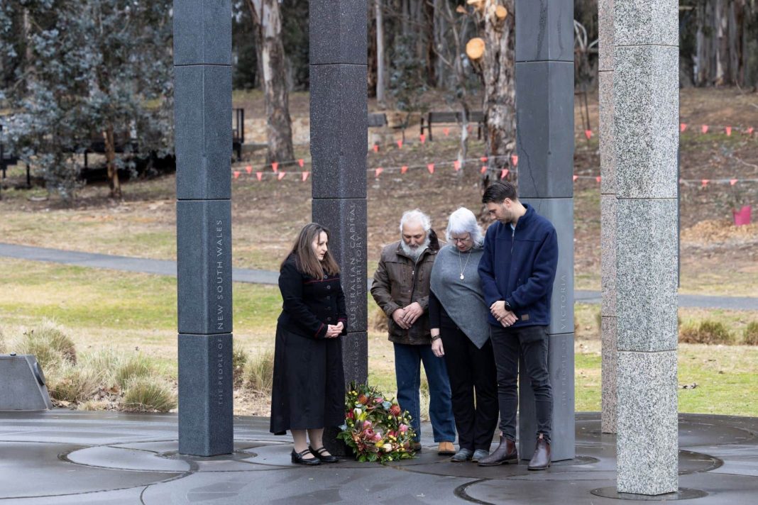 Two women and 2 men laying a wreath at the national workers memorial monument in Canberra