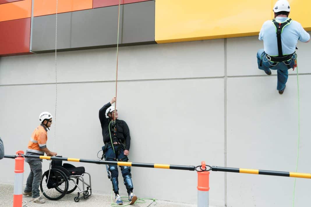 a man is seen wearing an exoskeleton after completing an 18m abseil down a multistorey building