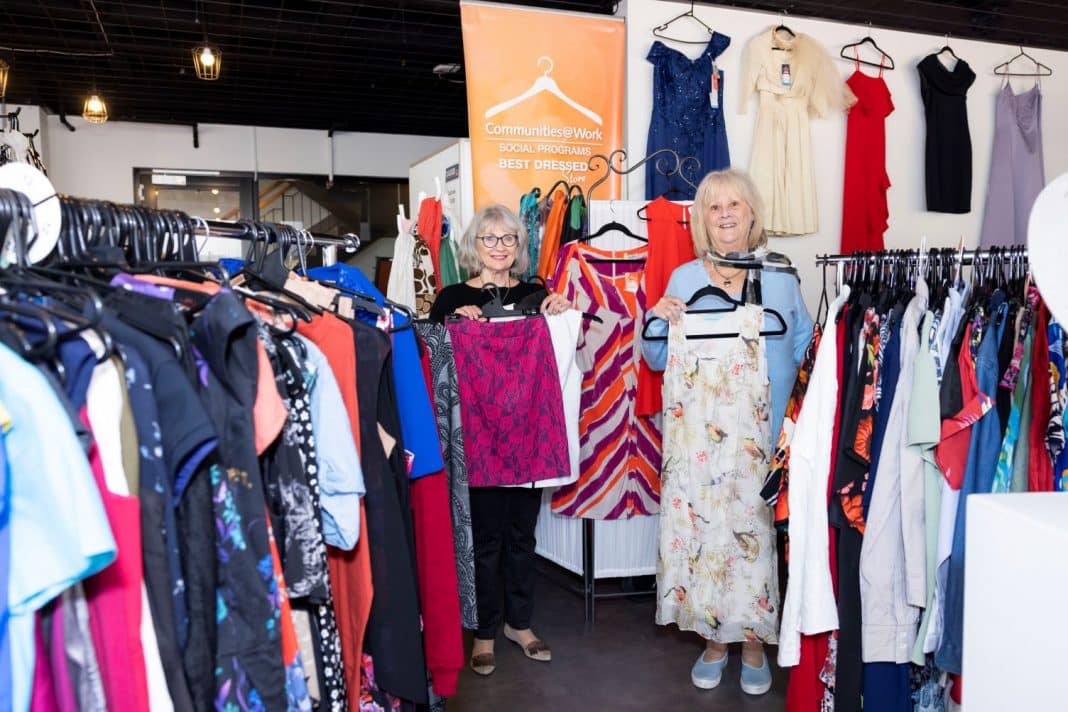 Two female volunteers arranging garments in a nice op shop in Manuka